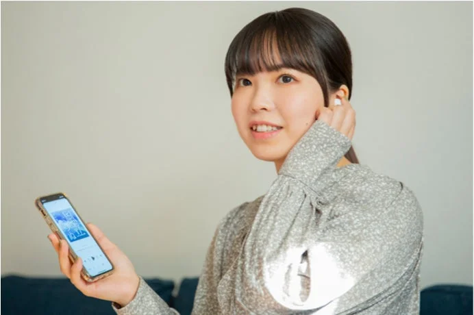 イヤホンでオーディオブックを聴く女性